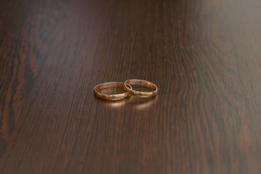 Alyanslar yakın planda, koyu ahşap bir yüzeyde yatıyor.