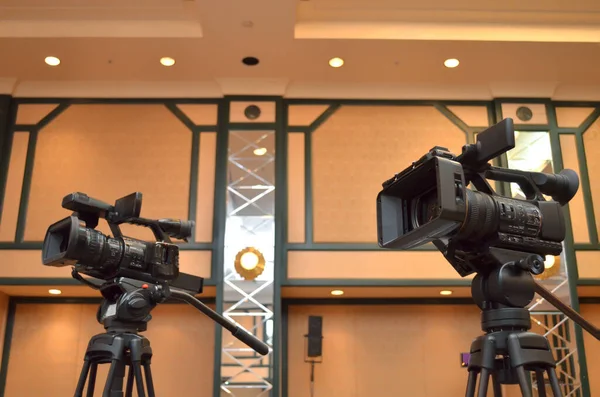 Two professional video cameras close up in the conference room