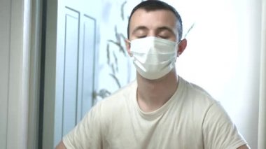 Tıbbi maskeli bir adam gözlerini açar COVID-19