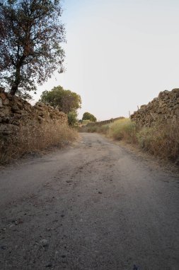 Gün batımından önce kırsal bölgede kum yolu. Turuncu egemenlik Yoğun ve parlak ışık
