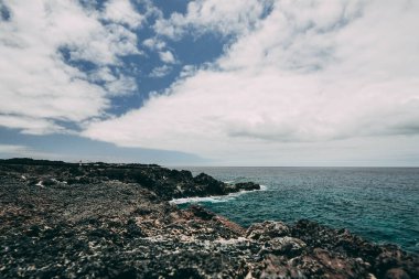 Lanzarote 'deki kayalıklar temiz mavi deniz suyuyla.