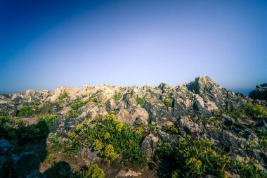 İspanya 'nın kuzeyindeki Asturias' taki kayalıklar. Mavi ve turuncu renkler. Yoğun mavi suyu olan dalgalı denizler..