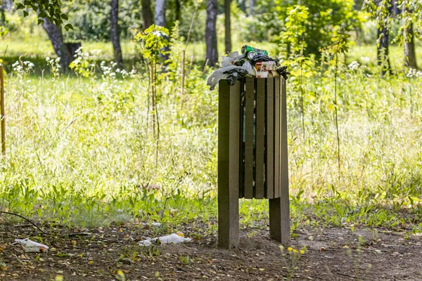 A full trash can in the local park