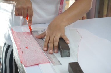 Asyalı kadın kağıt üzerine çiziyor, küçük işletme içeride.