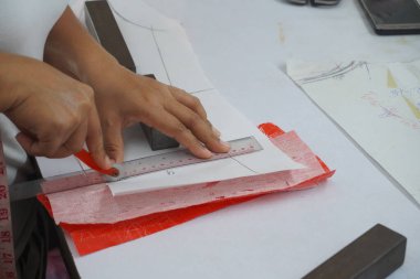 Asyalı kadın kağıt üzerine çiziyor, küçük işletme içeride.