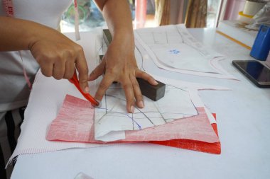 Asyalı kadın kağıt üzerine çiziyor, küçük işletme içeride.