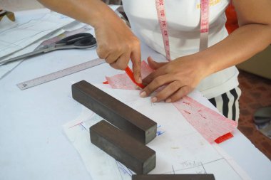 Asyalı kadın kağıt üzerine çiziyor, küçük işletme içeride.
