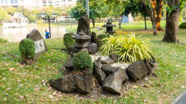 Bu resim parkta bir yerde olabilir, ön tarafta tapınağın etrafına bir sürü taş konmuş ve büyük taşlardan biri Çince harfler yazmış olabilir.. 