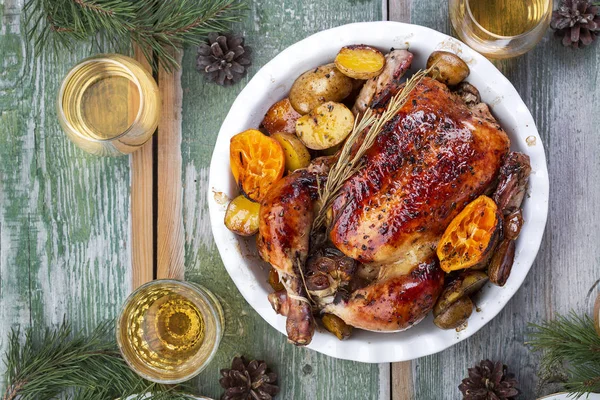 Roasted whole chicken with potatoes and tangerines
