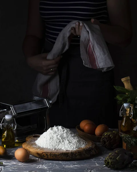 women's hands making pasta dark rustic style