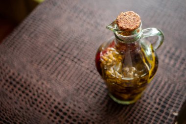 Ekstra saf zeytinyağı şişesi koyu bir masada.