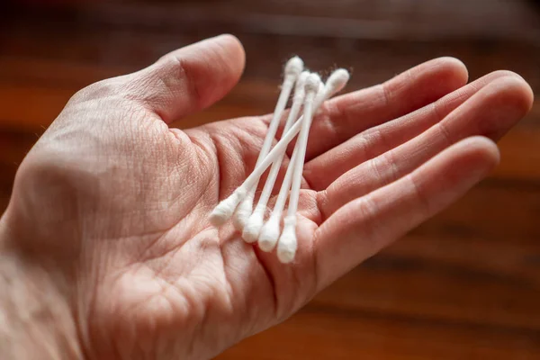 Hand holding some cotton swabs