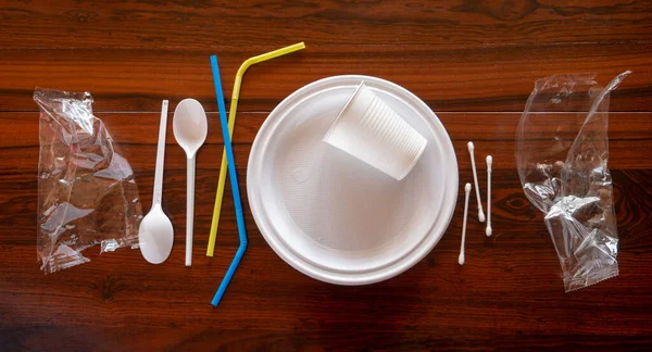 Tahta masadaki tek kullanımlık plastik çanak çömlek parçaları.