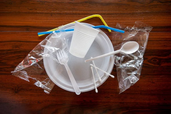 Tahta masadaki tek kullanımlık plastik çanak çömlek parçaları.