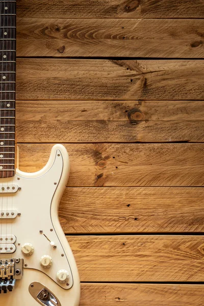 茶色の木製のテーブルの上の白いエレキギター コピースペース — ストック写真