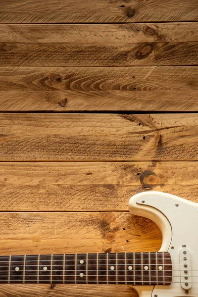 茶色の木製のテーブルの上の白いエレキギター コピースペース — ストック写真