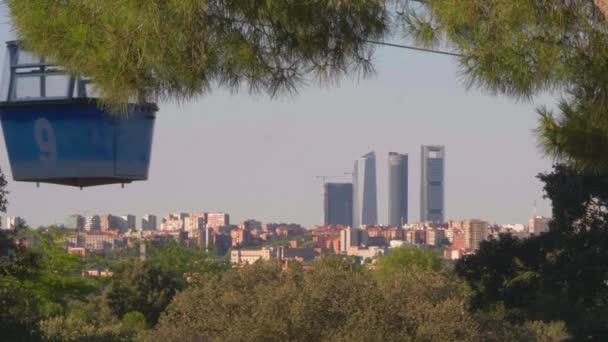 背後にあるクアトロ トーレス ビジネス エリアと呼ばれる4つの塔で走るマドリードのケーブルカーは 晴れた日に澄んだ空で — ストック動画