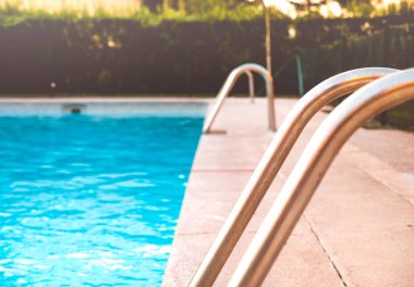 Bir yaz gününde tuzlu su havuzunun metal merdivenleri.