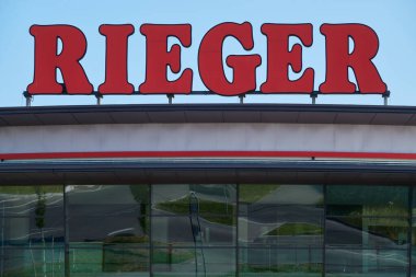 Goeppingen, Almanya - 21 Mayıs 2020: Mbel (mobilya) Rieger, Facade with big red letters, the beautiful around be reflect in the glass front. Goeppingen.