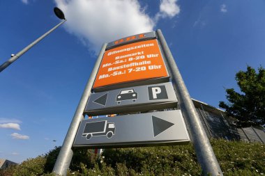 Goeppingen, Almanya - 21 Mayıs 2020: Açılış saati ve tabelalı Obi tabelası, yeşil çit ve arka planda güzel sokak lambası. Goeppingen.