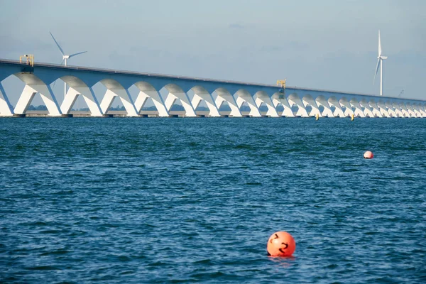 Lange Zeeland Brücke Tiefblaues Wasser Mit Roter Boje Windkraftanlage Hintergrund — Stockfoto