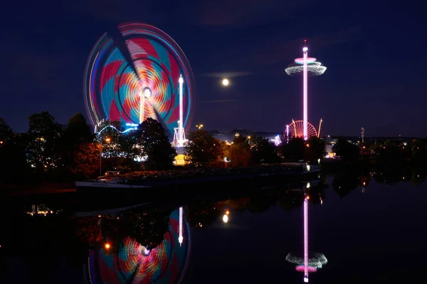 Stuttgart Bad Canstatt, Almanya - 11 Ekim 2019: Folk festivalinin dönme dolabının görüntüsü, mavi gökyüzüne karşı eğlence gezisi, uzun pozlama. Stuttgart, Almanya.