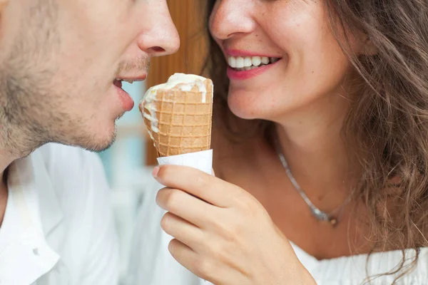 Close portrait of smiling man and woman with ice cream cone. lower face, lips