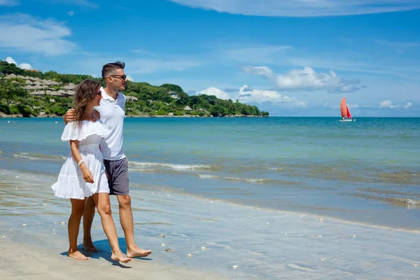 Couple de plage marchant sur voyage romantique vacances lune de miel vacances d'été romance. Jeunes amants heureux, femme et homme tenant la main embrassant à l'extérieur. — Photo