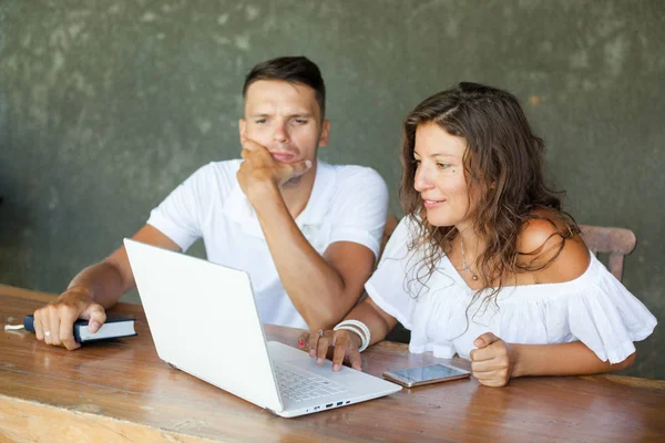 Amor, familia, tecnología, internet y concepto de felicidad - pareja joven en blanco con computadora portátil en el escritorio de búsqueda, interior, interior — Foto de Stock