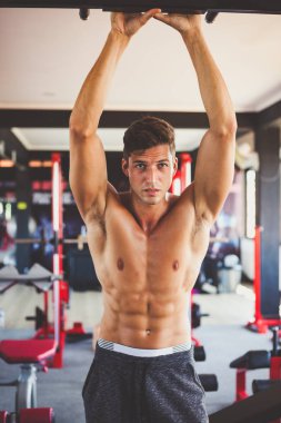 spor salonunda çıplak uygun bir gövde ile yakışıklı bir genç sportif adam portre. adam elleri ile ayakta