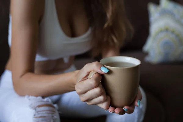 Kvinnliga händer håller Broun kopp te, färg manikyr, flickan är klädd i vita kläder. horisontell ram — Stockfoto