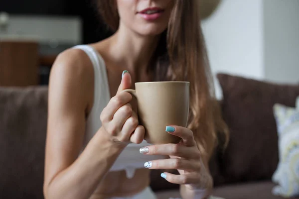 Kvinnliga händer håller Broun kopp te, färg manikyr, flickan är klädd i vita kläder. horisontell ram — Stockfoto