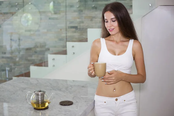 elinde kupa ile güzel gülümseyen kız inkitchen ayakta 