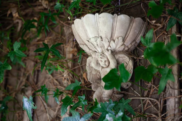 Estatuilla tallada en piedra retro de un ángel con alas sosteniendo una copa de alivio sobre su cabeza. decoración del jardín — Foto de Stock