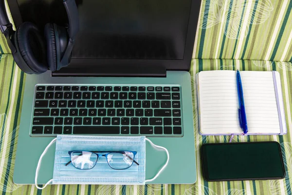 security and safety. medical face mask lies at the workplace of a freelancer. Work from home. computer, electronic gadgets, home office, comfort