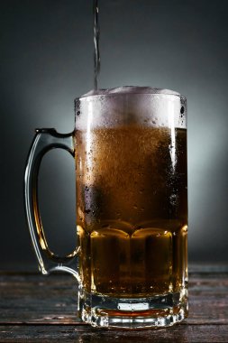 Tahtada köpük olan bira bardağı.