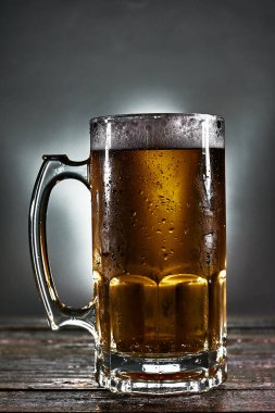 Tahtada köpük olan bira bardağı.