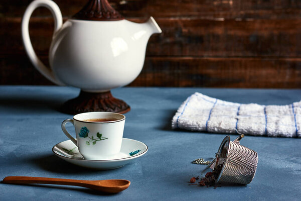 tea cup with teapot and infuser strands with accessories