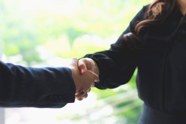 İş adamları, ofiste görüştükten sonra yeni çalışanları tebrik etmek için el sıkışıyor. Tutuyorum, iş kadını..