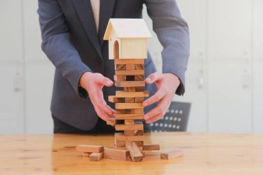 Kuledeki ahşap blokta işadamı koruması. İş hayatında plan ve strateji.