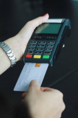 Žena používající ruční kreditní kartu na prodej produktů v obchodě. Koncept utrácení kreditní kartou.