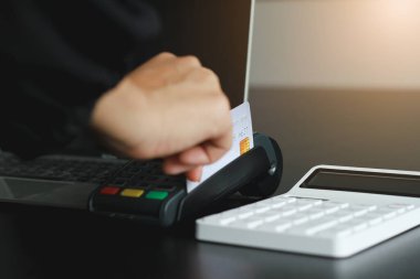 Dükkanda ürün satmak için kredi kartı okutma makinesi kullanan bir kadın. Kredi kartıyla harcama kavramı.