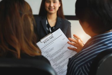 Özgeçmiş tutan İK personeliyle yapılan iş görüşmelerinin yakın plan görüntüsü ve önceden hazırlanmış becerileri olan başvuru sahiplerinin geçmiş kontrolleri.