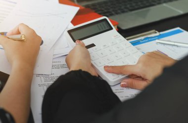 Hesap makinesine basmak için parmaklarını kullanan iş kadınları. Finansal, muhasebeci..