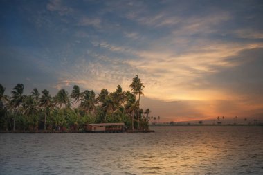 Kumarakom, Kerala, Hindistan 'ın durgun sularında dramatik günbatımı. Kerala, durgun sularıyla tanınan ve dünya çapında turistler için popüler bir turizm beldesi..