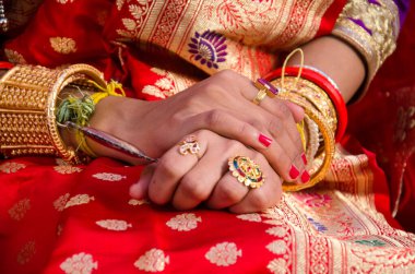 Bir gelinin elleri, kırmızı bir sari ve Hint düğün töreninde geleneksel mücevherler içinde..