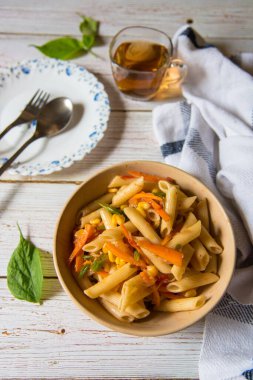 Kasede makarna, arka planda çay ve seçici bir odak kullanımı.