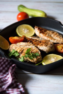 Seçici odaklı tavada malzemeli tavuk bifteği ve sos.