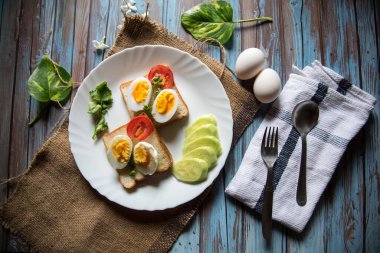 Haşlanmış yumurta, ekmek ve sebzelerin sağlıklı besin maddelerinin üst görüntüsü