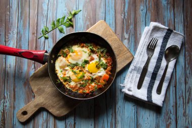 Popüler yemek Shakshuka arka planda siyah bir tavada 